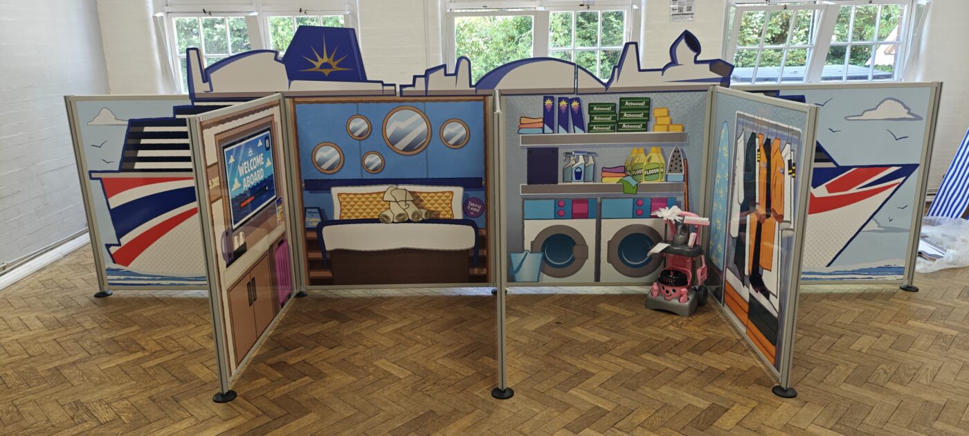 Complete flat-pack role-play village installation featuring freestanding scenic panels and interactive props ready for play onboard P&O Cruises.