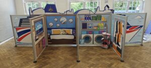 Complete flat-pack role-play village installation featuring freestanding scenic panels and interactive props ready for play onboard P&O Cruises.