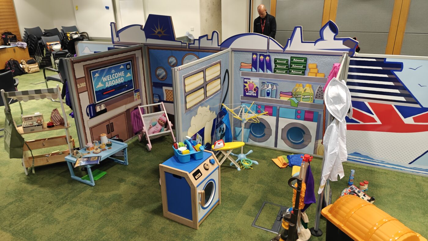 Complete flat-pack role-play village installation featuring freestanding scenic panels and interactive props ready for play onboard P&O Cruises.