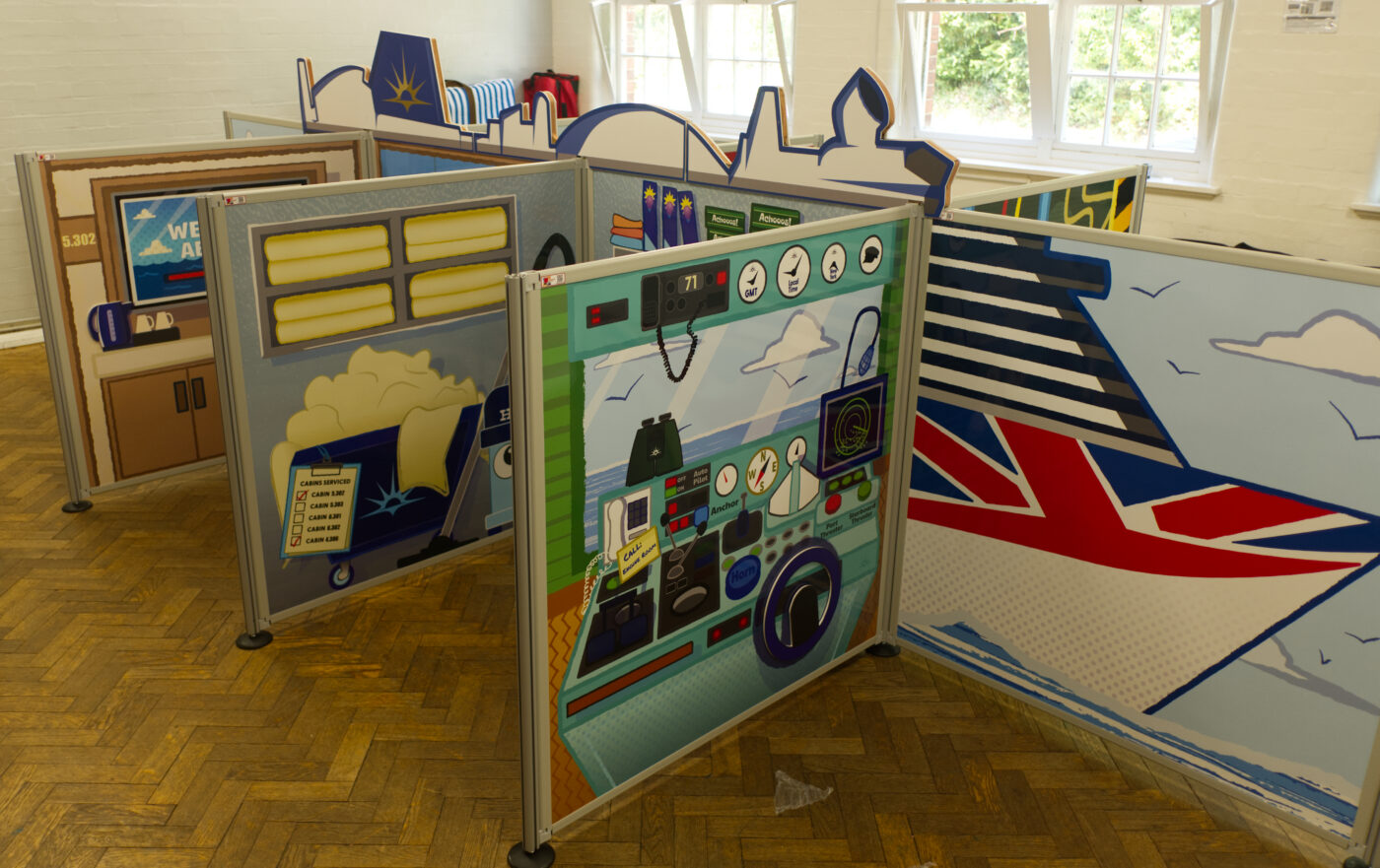 Complete flat-pack role-play village installation featuring freestanding scenic panels and interactive props ready for play onboard P&O Cruises.